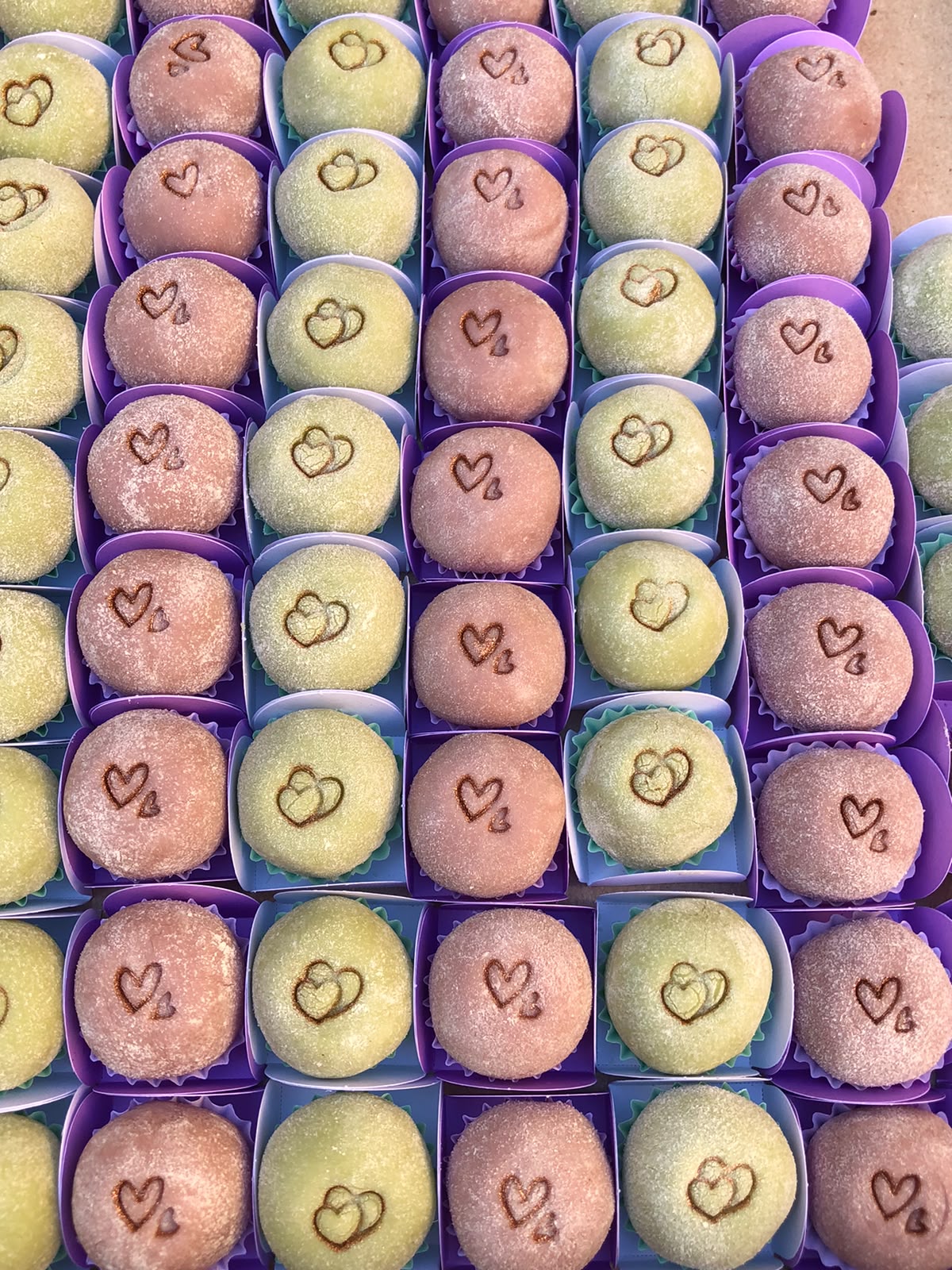 Brigadeiros gourmet em tons de rosa e verde com decoração de corações